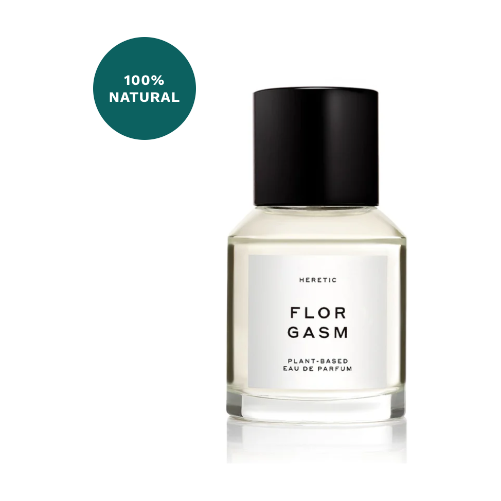 A clear glass bottle of Heretic Parfum Florgasm plant-based eau de parfum labeled "100% natural," enhanced with Jasmine fragrance, on a white background.