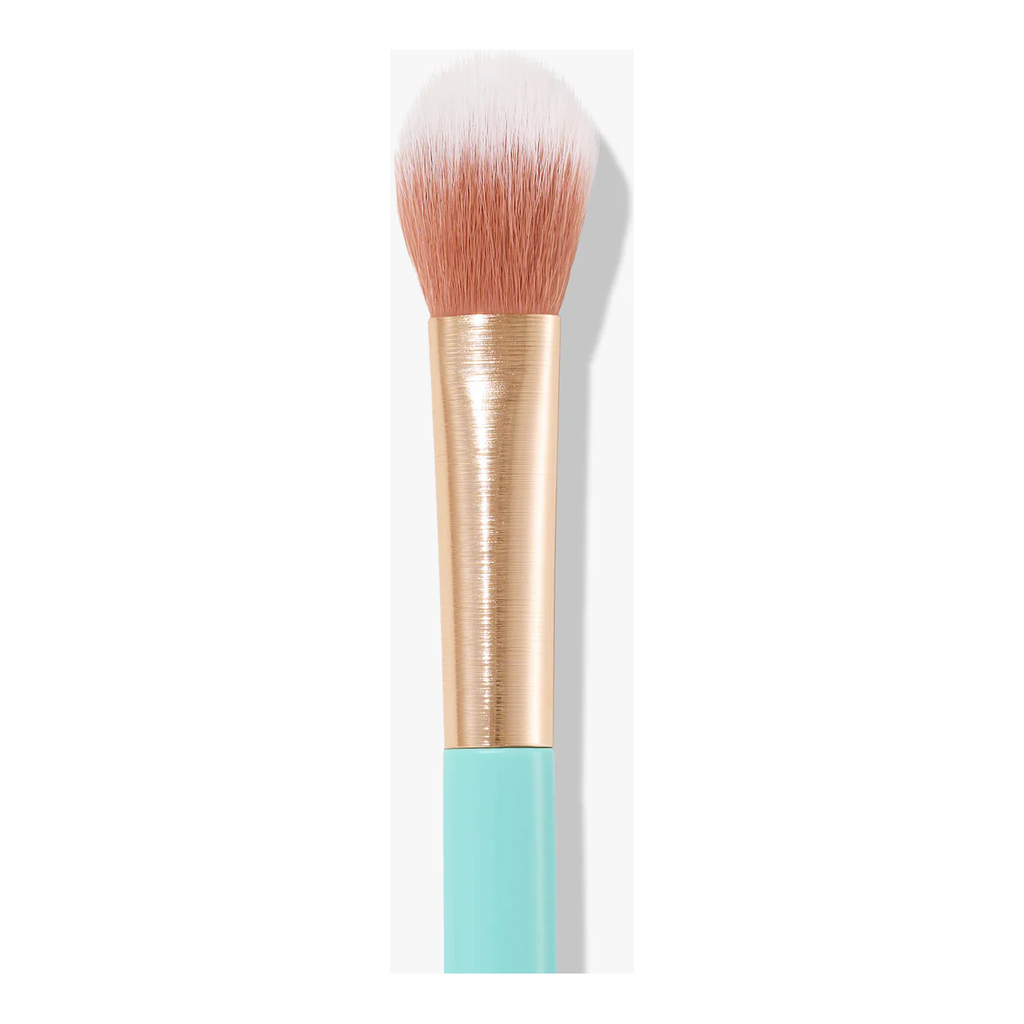 The Sweed 05 Highlighter Brush features white and pink bristles, a gold ferrule, and a light blue handle against a white background, making it perfect for achieving a natural glowing result.