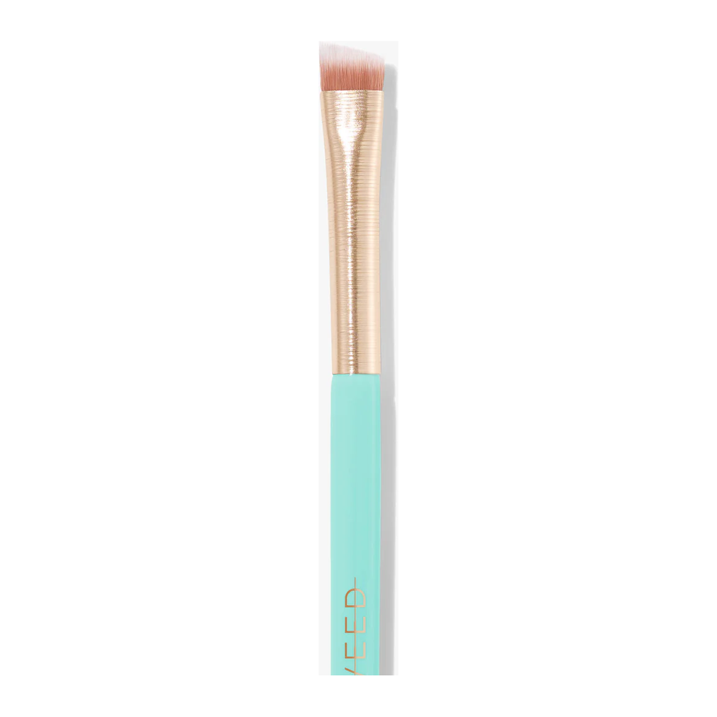 A close-up of the Sweed 08 Duo Brow and Liner Brush, showcasing its teal handle, gold ferrule, and angled synthetic bristles.