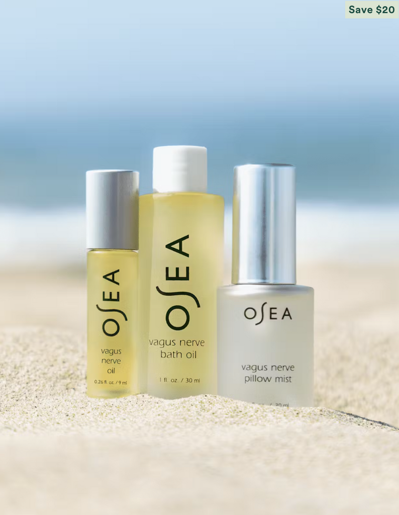 Three OSEA products on a sandy surface with a blurred blue background