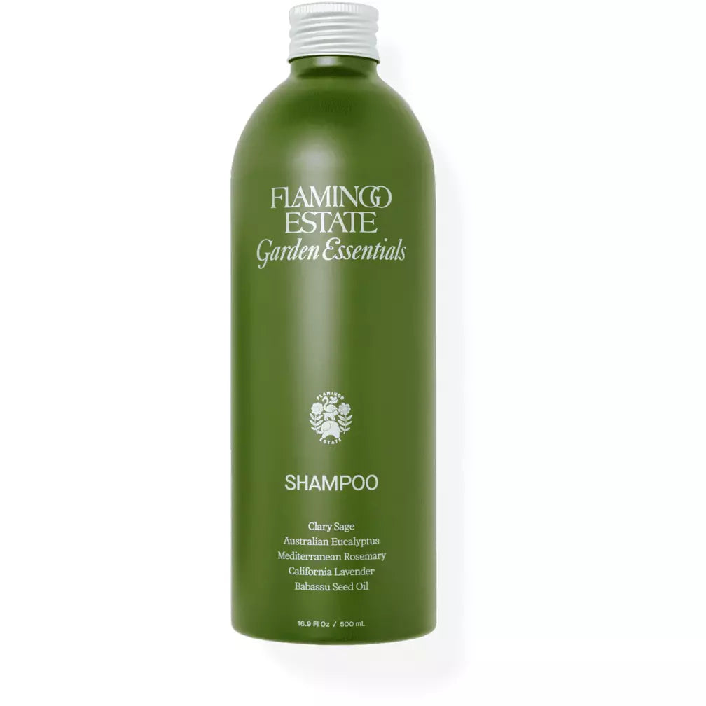 Green shampoo bottle with the label "flamingo estate garden essentials shampoo" featuring ingredients like australian eucalyptus, mediterranean rosemary, californian lavender, and rooib.