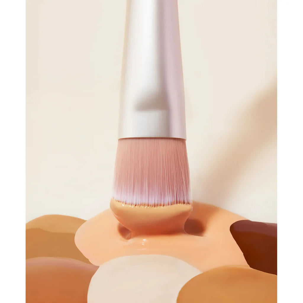 Makeup brush with bristles coated in liquid foundation.