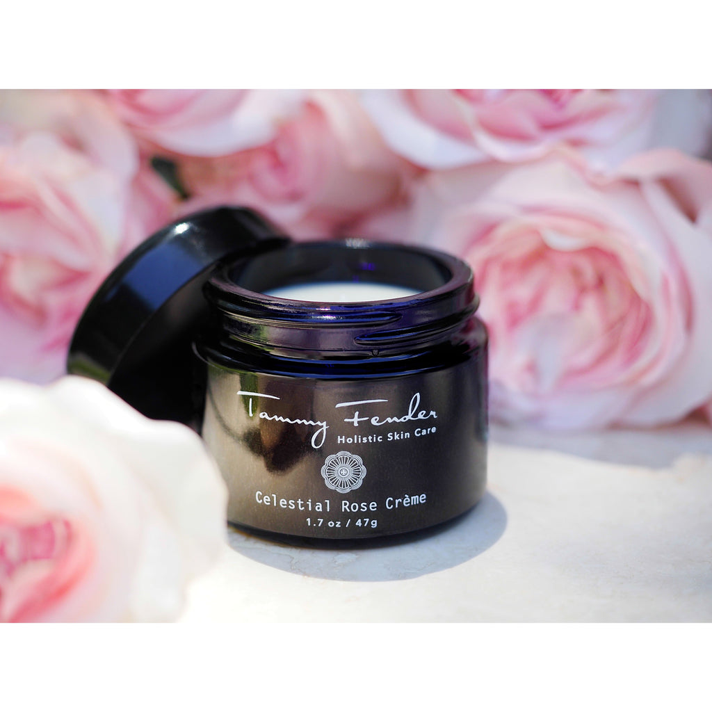A jar of tammy fender celestial rose crÃ¨me surrounded by soft pink roses.