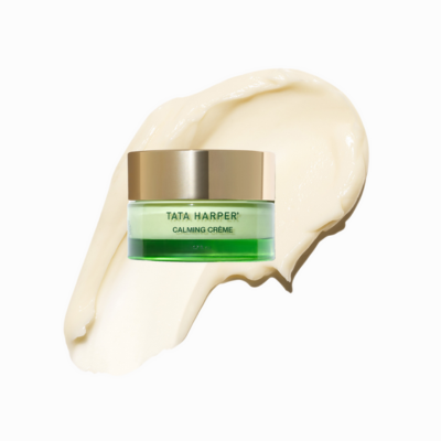 A jar of Tata Harper Superkind Calming Cream for stressed skin on a creamy product smear background.