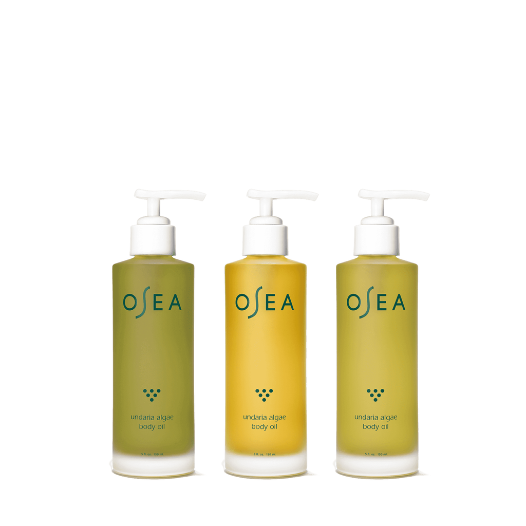 Three bottles of osea undaria algae body oil with pump dispensers.