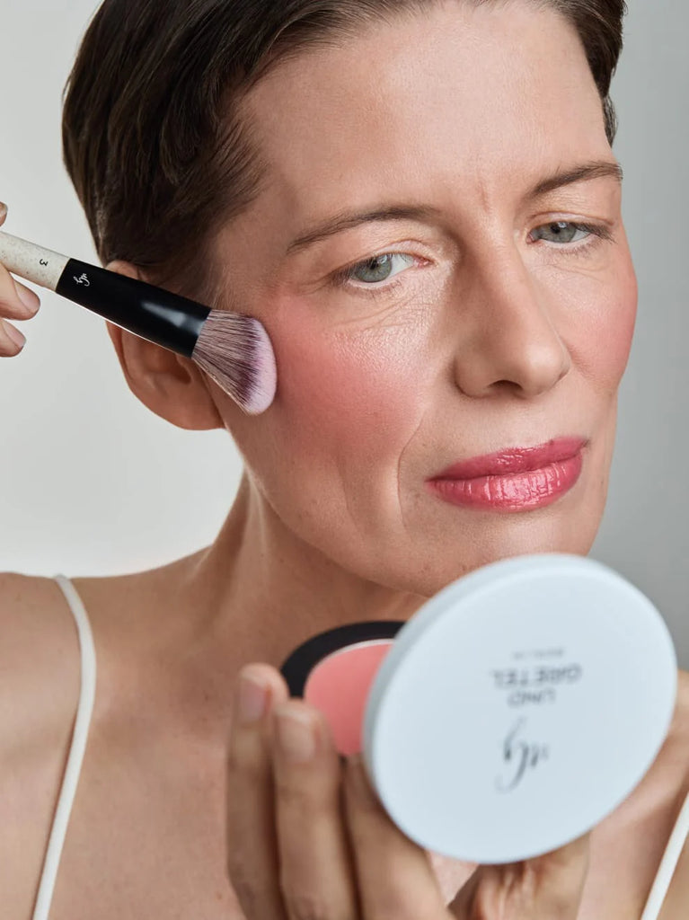 Model Applying Und Gretel WONNE Blush Duo Soft-focus powder blush.