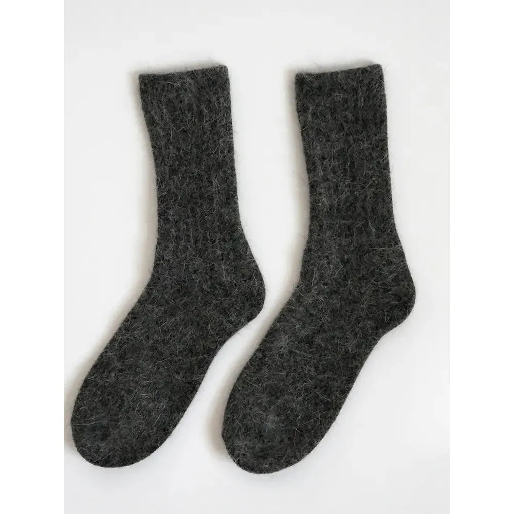 A pair of dark gray wool socks on a white background.
