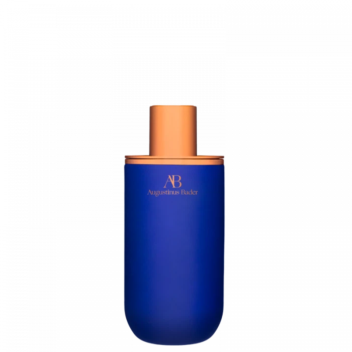 A blue bottle of augustinus bader skincare product with an orange cap against a black background.
