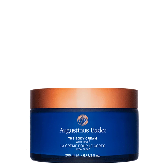 Container of augustinus bader body cream on a white background.