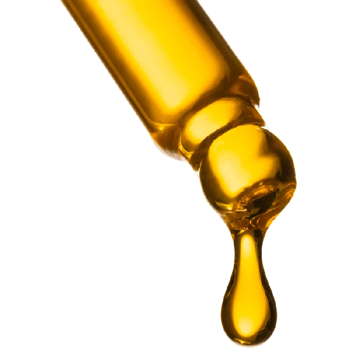 A dropper releasing a viscous, golden liquid against a white background.