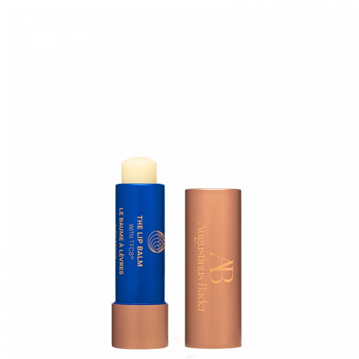 Two lip balm sticks with caps off, one with a blue label and the other with a bronze label, against a black background.