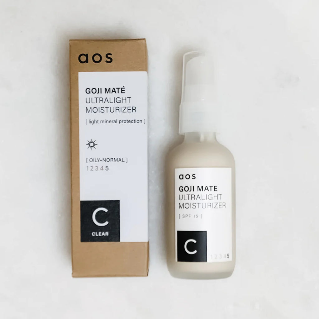 A bottle of aos goji mate ultralight moisturizer with spf 5 next to its packaging.