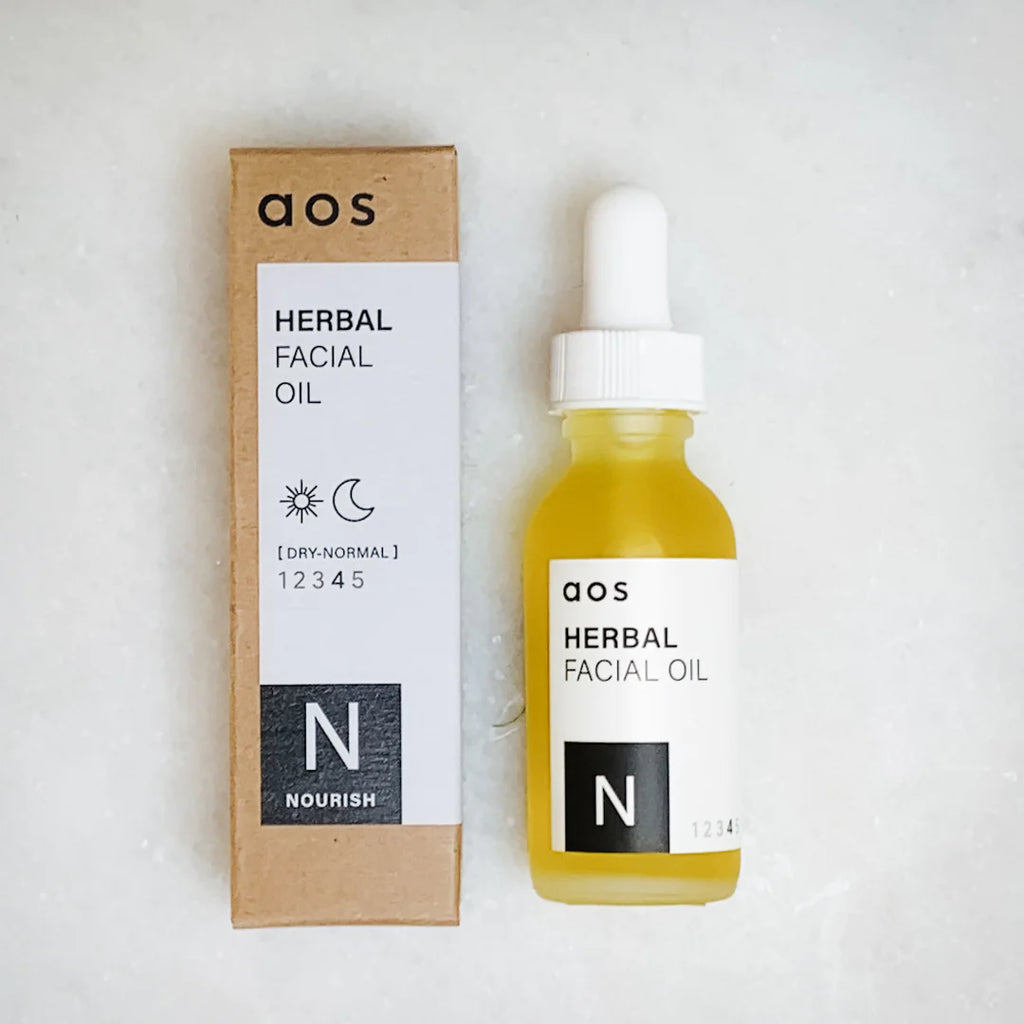A bottle of herbal facial oil next to its packaging.