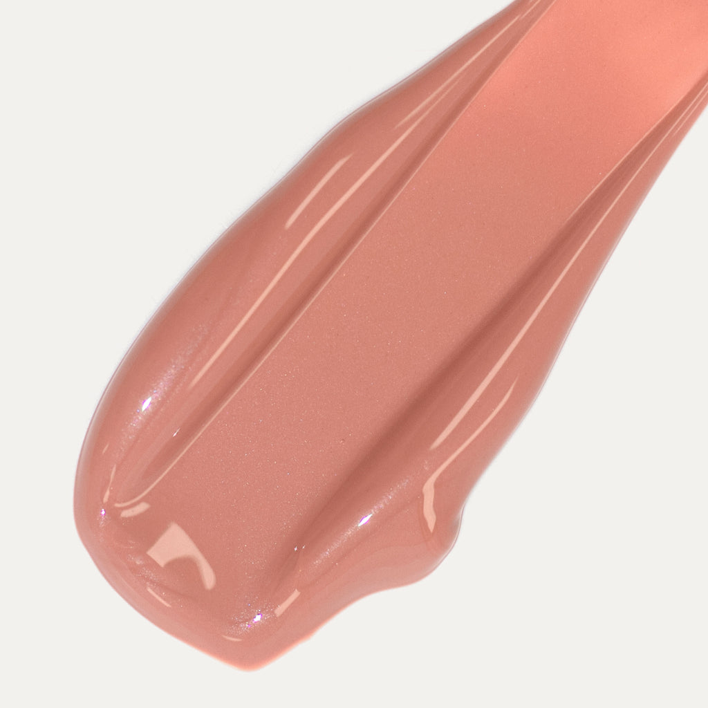 A close-up of a smear of pinkish-beige lip gloss.