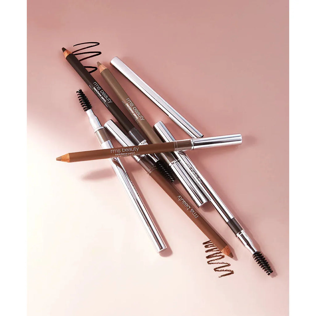 A collection of eyebrow pencils with caps and built-in brushes on a pink surface.