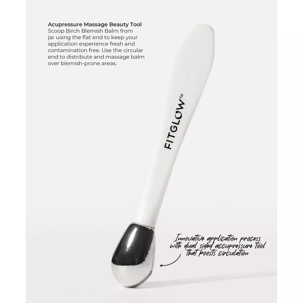 A white acupressure massage beauty tool labeled "fitglow" designed for scooping and applying balm to the skin, with instructions for a lymphatic application process to reduce puffiness.