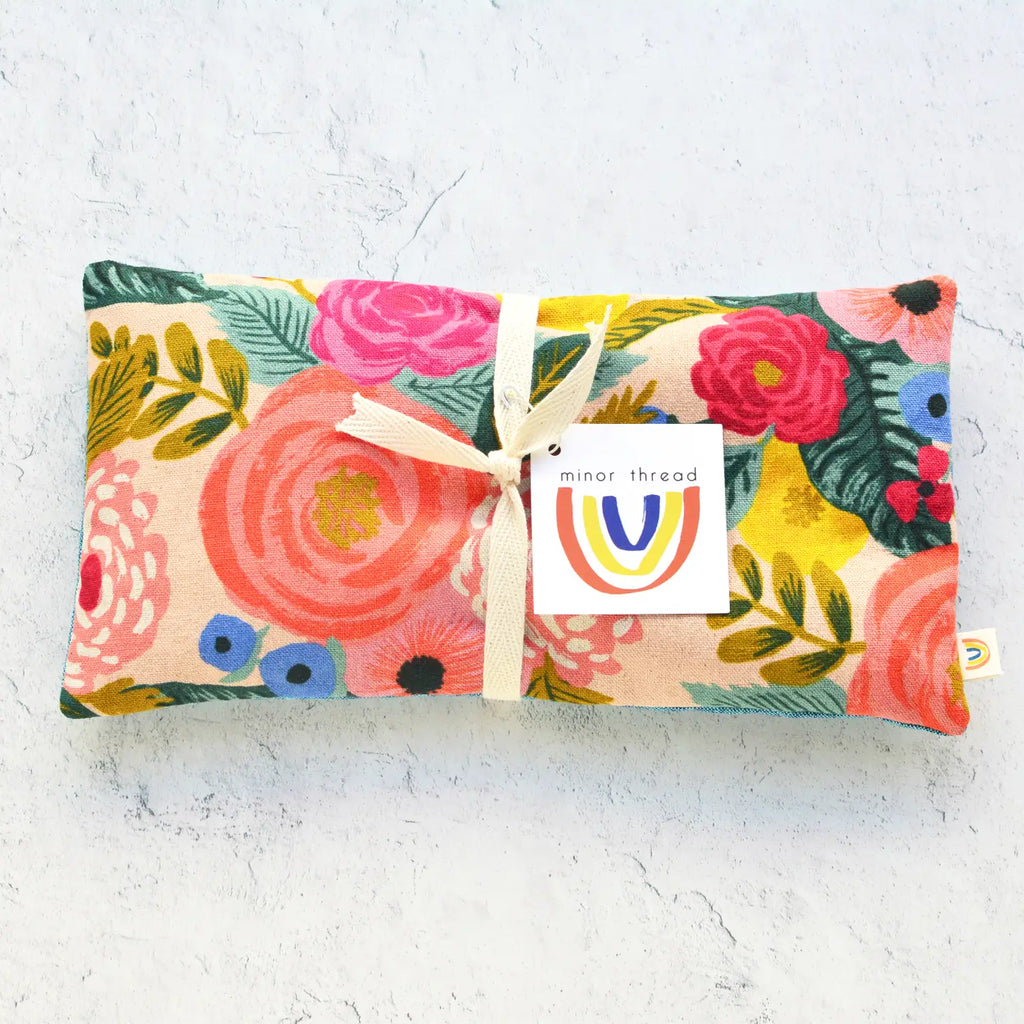 Floral patterned cloth pouch with a bow and brand tag.