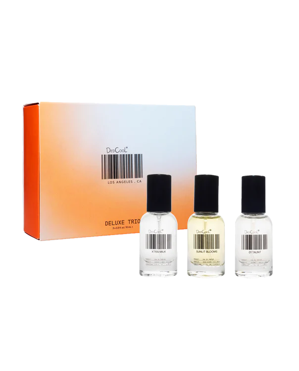 Three perfume bottles with black caps and a box labeled 'Deluxe Trio' on a white background.