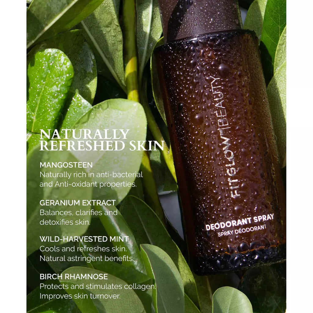 A bottle of natural deodorant spray with key ingredients and benefits listed, nestled among green leaves.