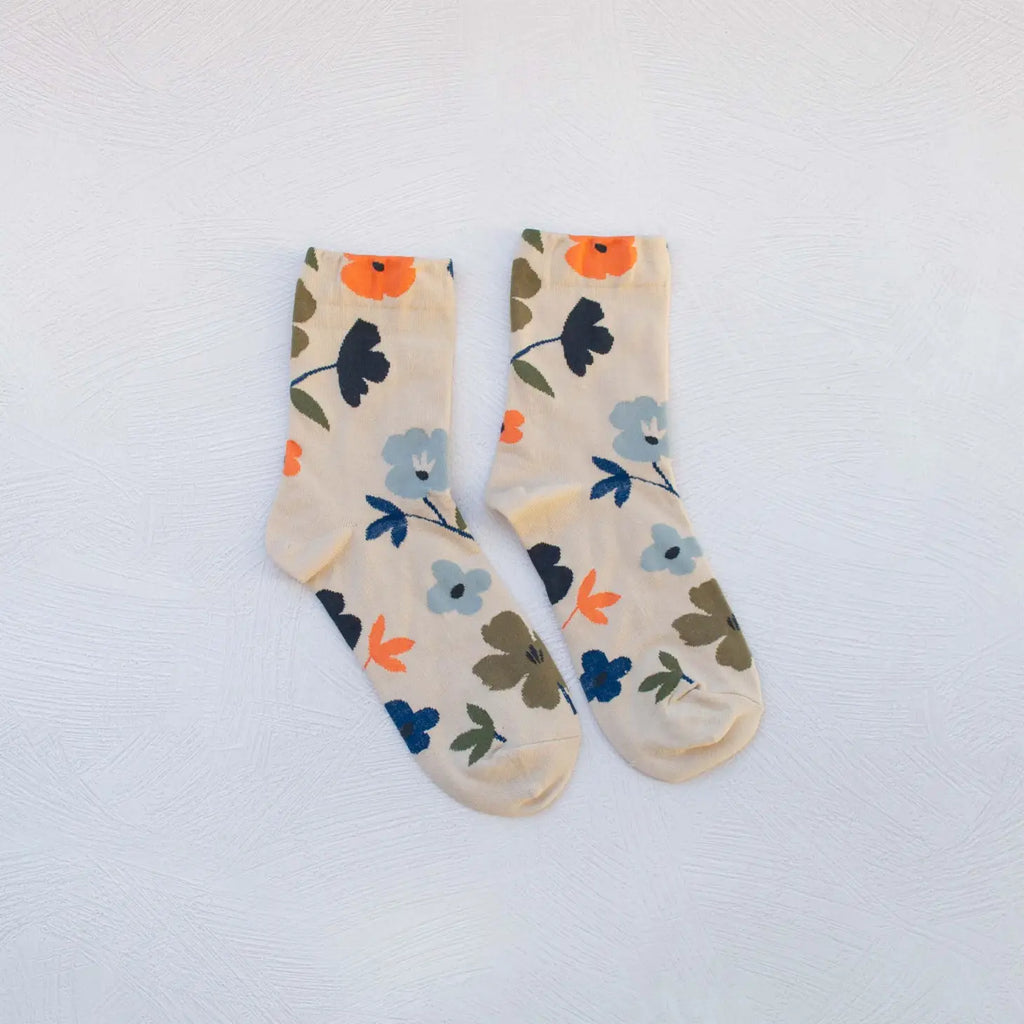 A pair of floral patterned socks laid out flat on a white surface.