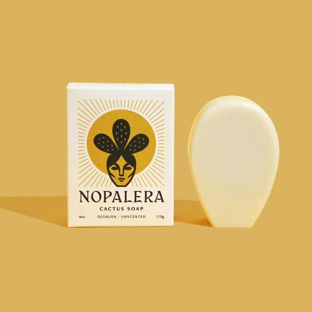 A bar of cactus soap next to its packaging with the name 'noplaera' on a plain background.