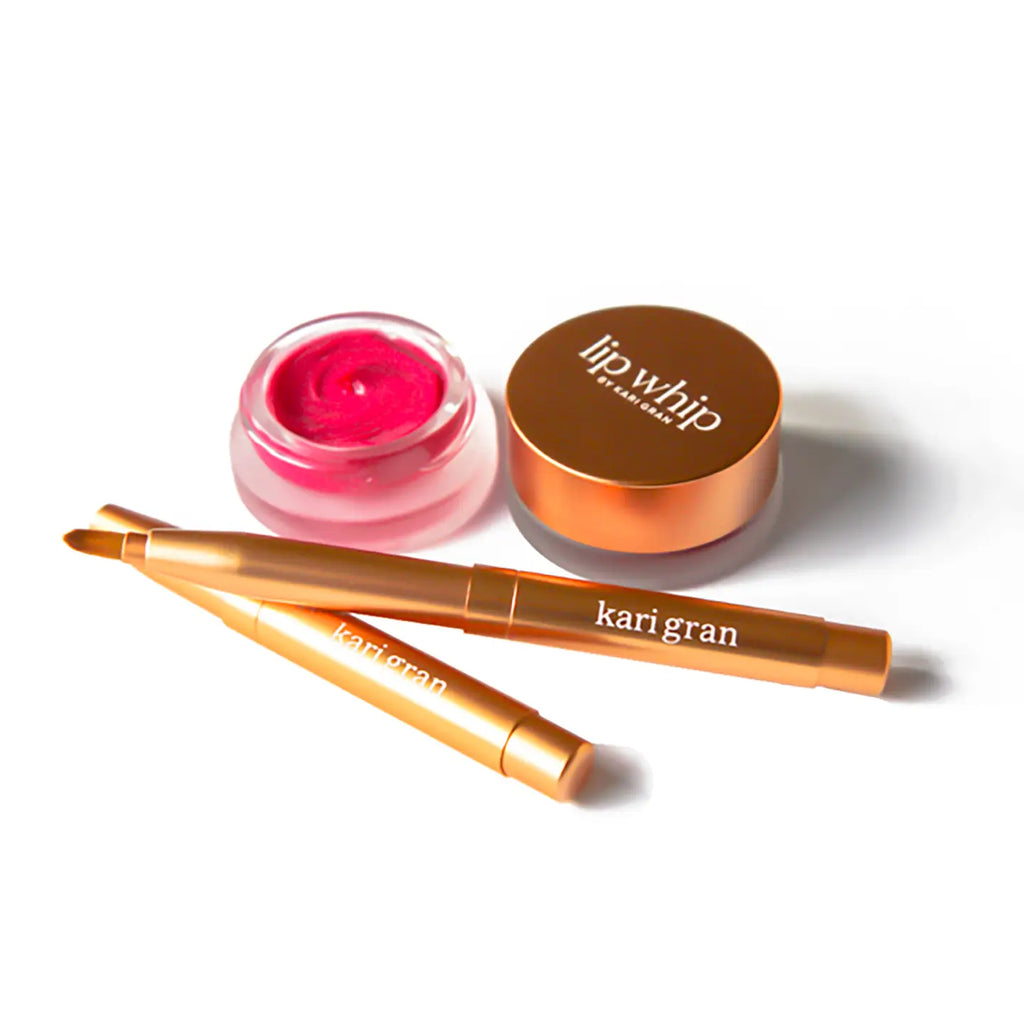 A selection of cosmetic products including two lip pencils and a pot of lip balm.