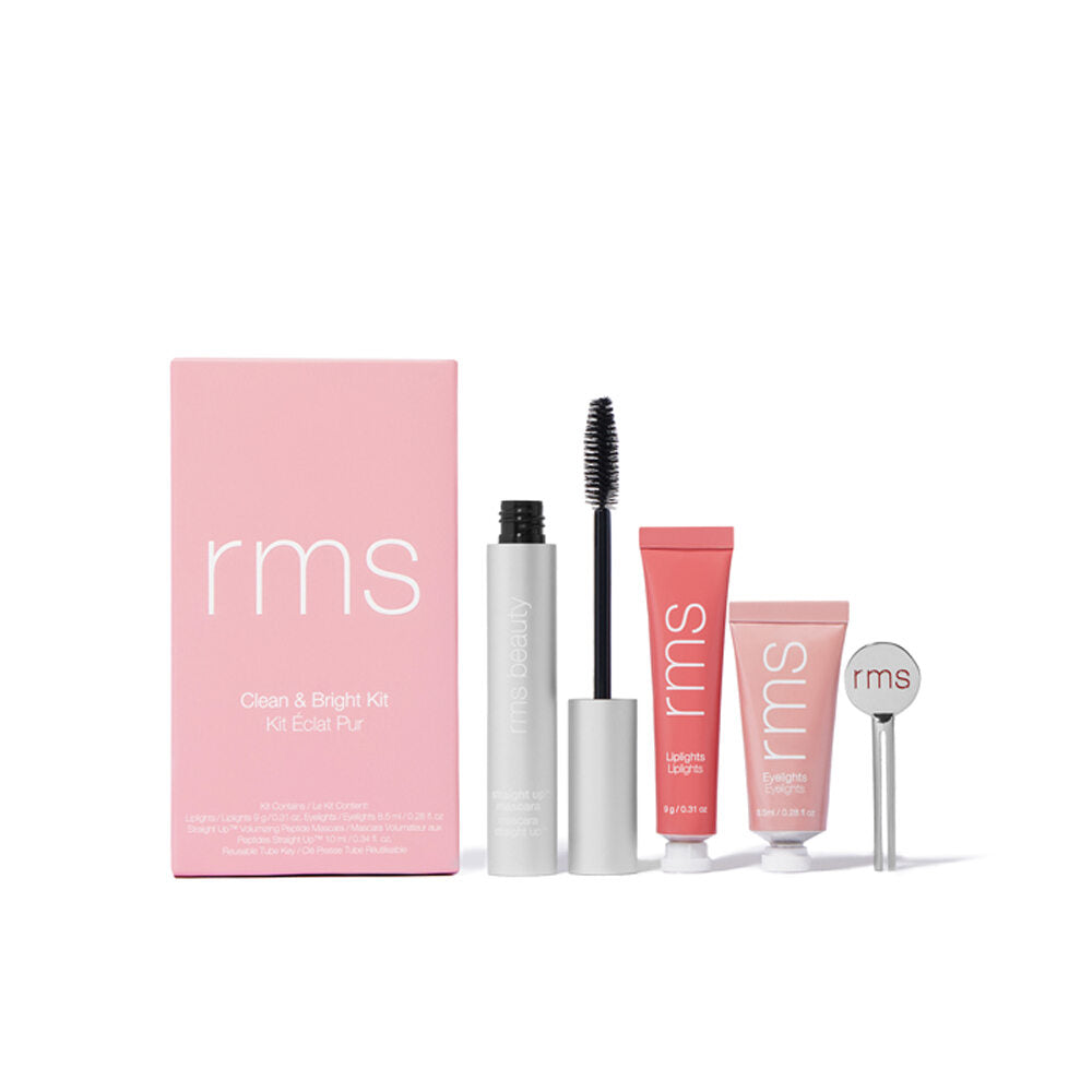 A set of rms beauty products including mascara, lip balm, and miniature skincare tubes, displayed next to their packaging.