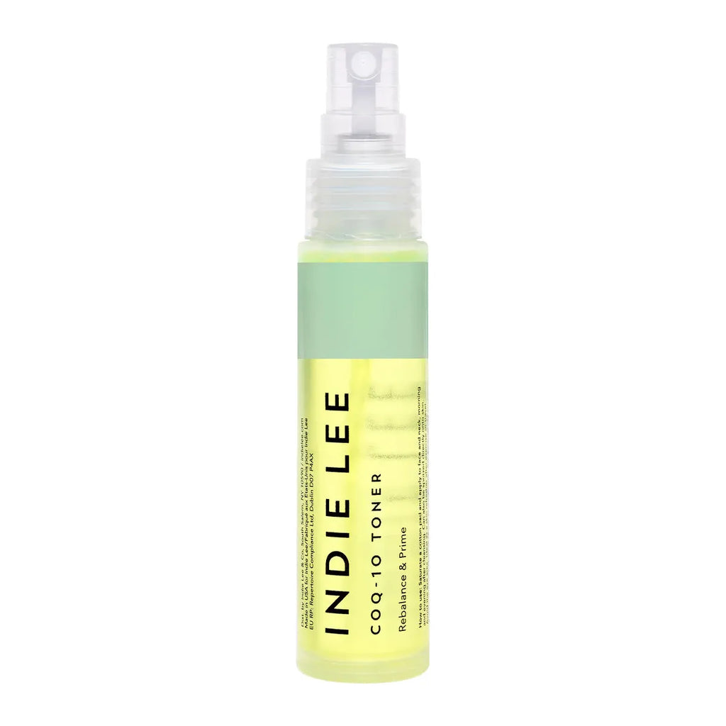 Transparent spray bottle of indie lee coq-10 toner with yellow-green liquid.