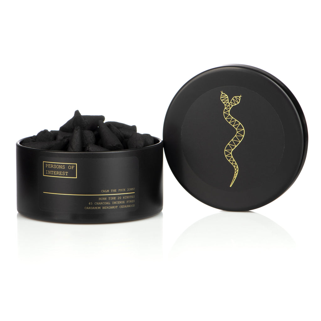 Black charcoal nose strips in an open container with lid displaying a golden design.