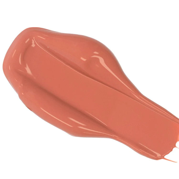 A smear of coral-colored liquid lipstick on a plain background.