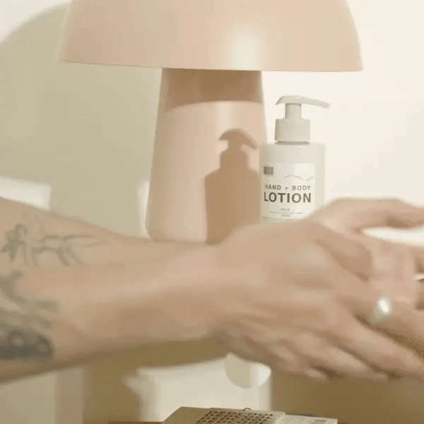Applying lotion from a pump bottle on a tabletop.