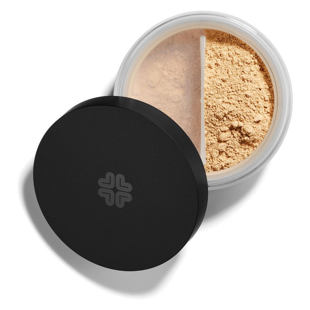 Loose face powder in an open container with a black lid.