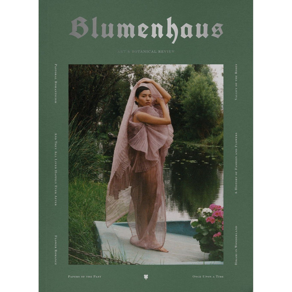 A woman in a flowing pink dress poses near a pond, surrounded by lush greenery, evoking the serene charm of a Garden Cottage Revolution. The cover text reads "Blumenhaus Issue #4" along with various article titles.