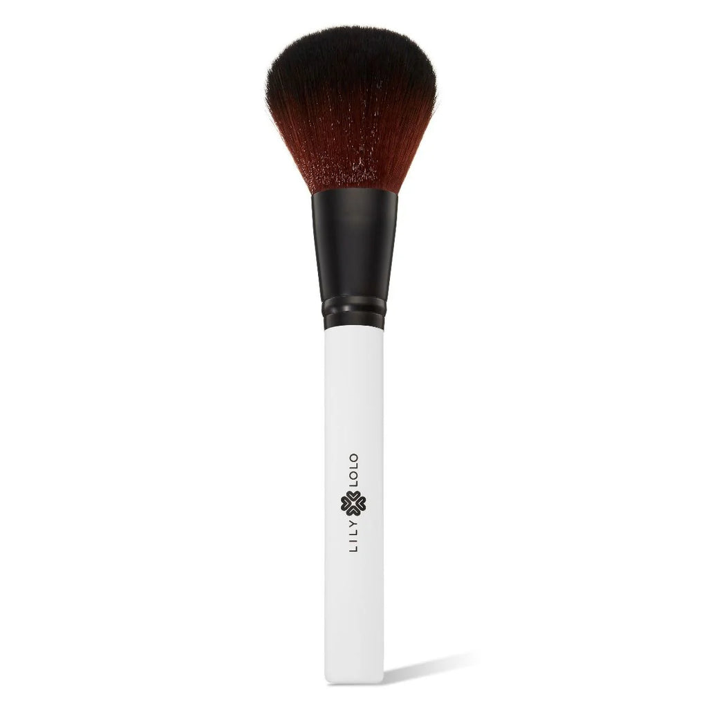 Introducing the Lily Lolo Powder Brush: a professional makeup brush with a sleek black handle and elegant white base. It features soft, densely packed bristles, making it perfect for flawless powder application.