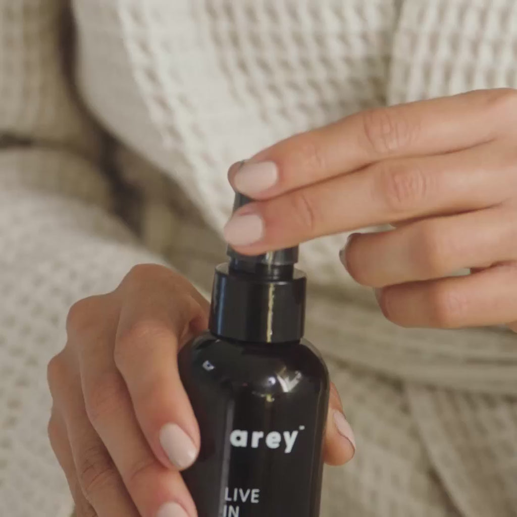 Video of a person spraying Arey Live In Mist into their hair