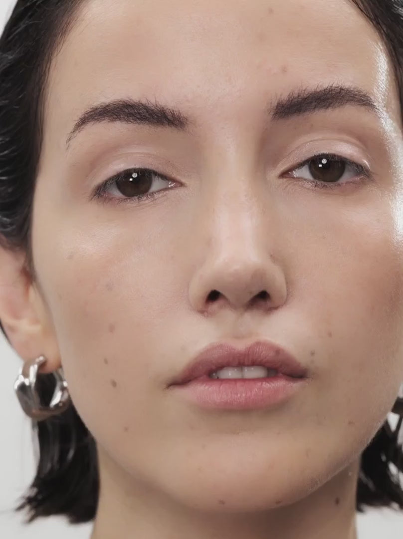 Model applying BALANCED FAIR 02: Light, neutral beige in a soft-creamy stick for a soft-focus finish with buildable coverage. Ideal for light skin types, it blends effortlessly into the skin, conceals redness, smoothes fine lines and offers a light, velvety feel.