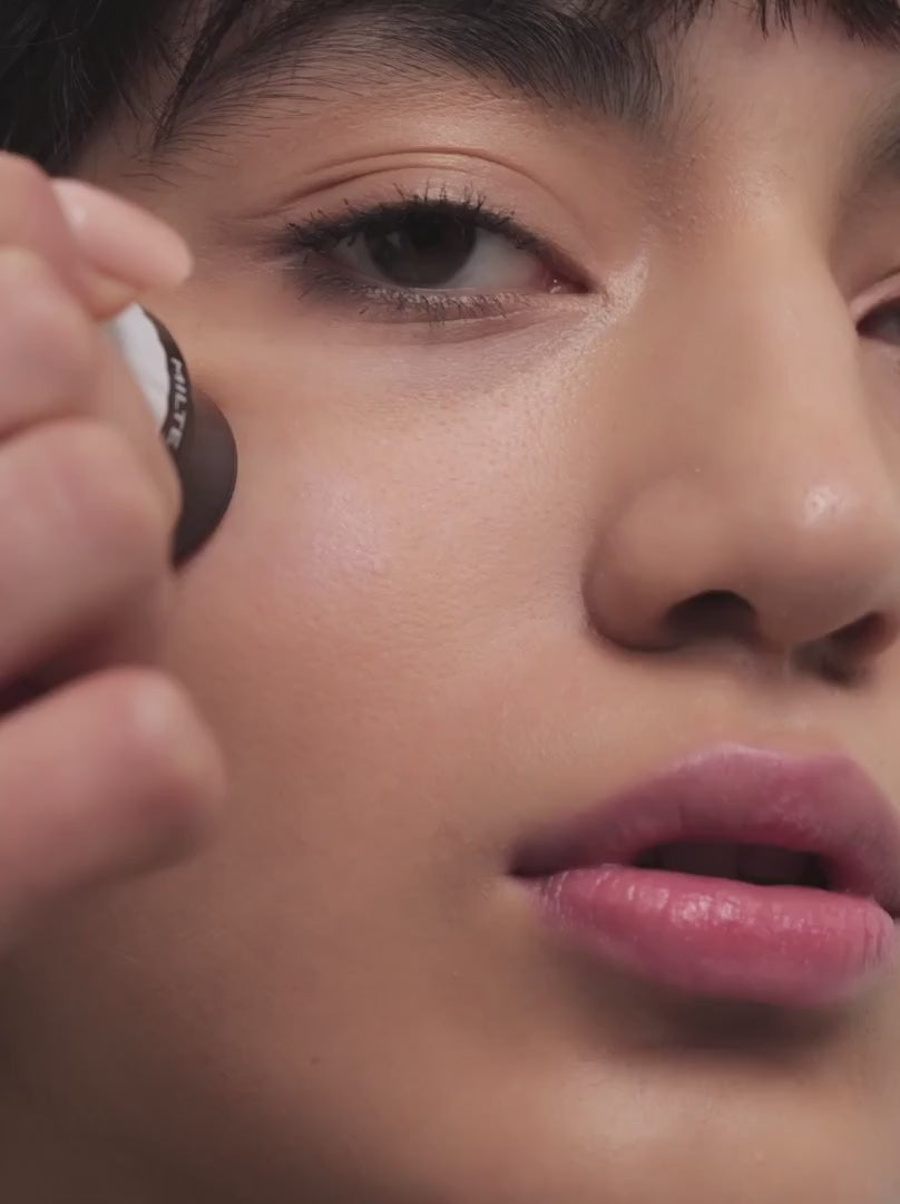 Model applying Und Gretel Highlighter Stick Illuminating Skin Finish