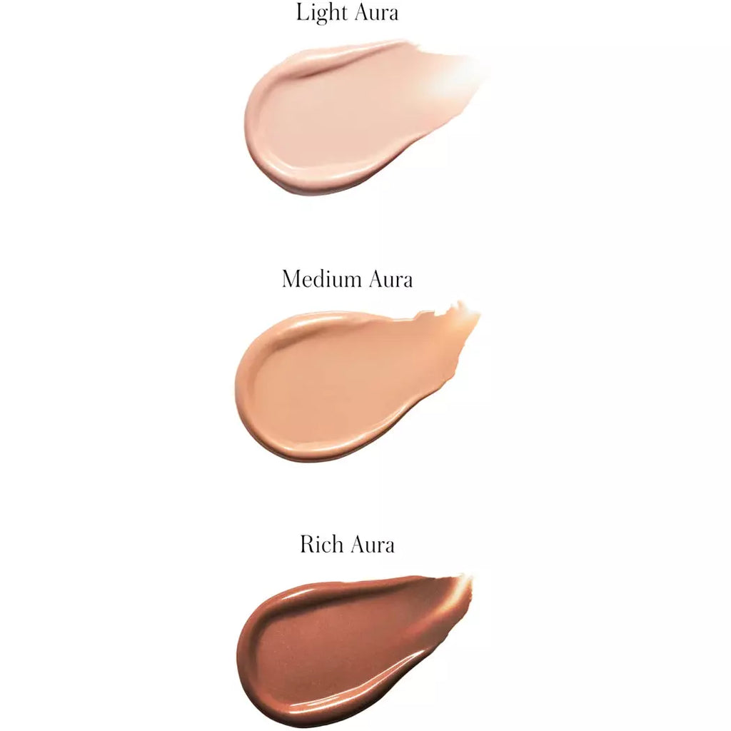 Three swatches of foundation makeup in varying shades labeled as light aura, medium aura, and rich aura.