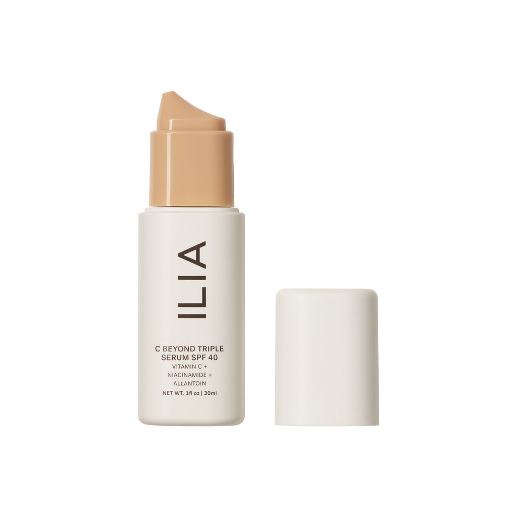 A bottle of ilia skin serum foundation with its cap removed beside it.
