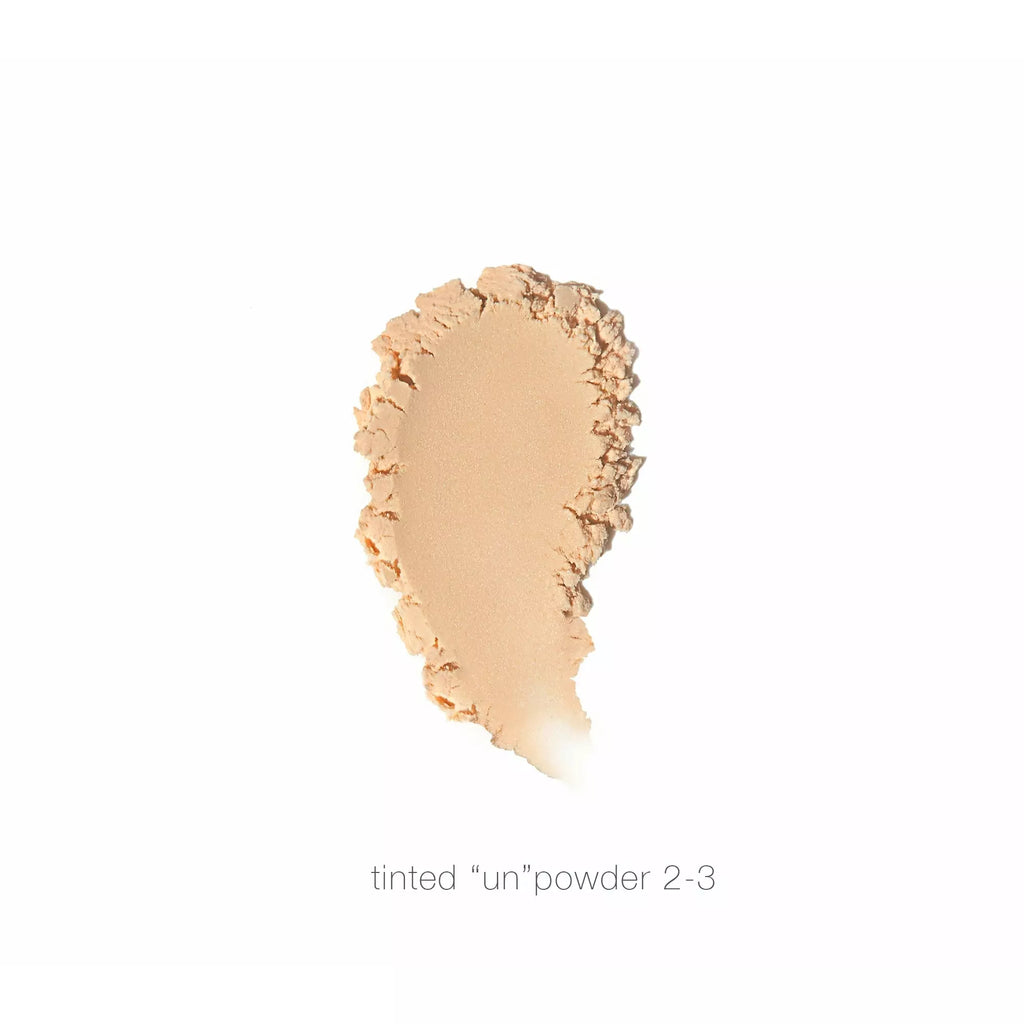Swatch of tinted powder makeup, shade 2-3, applied on a white background.