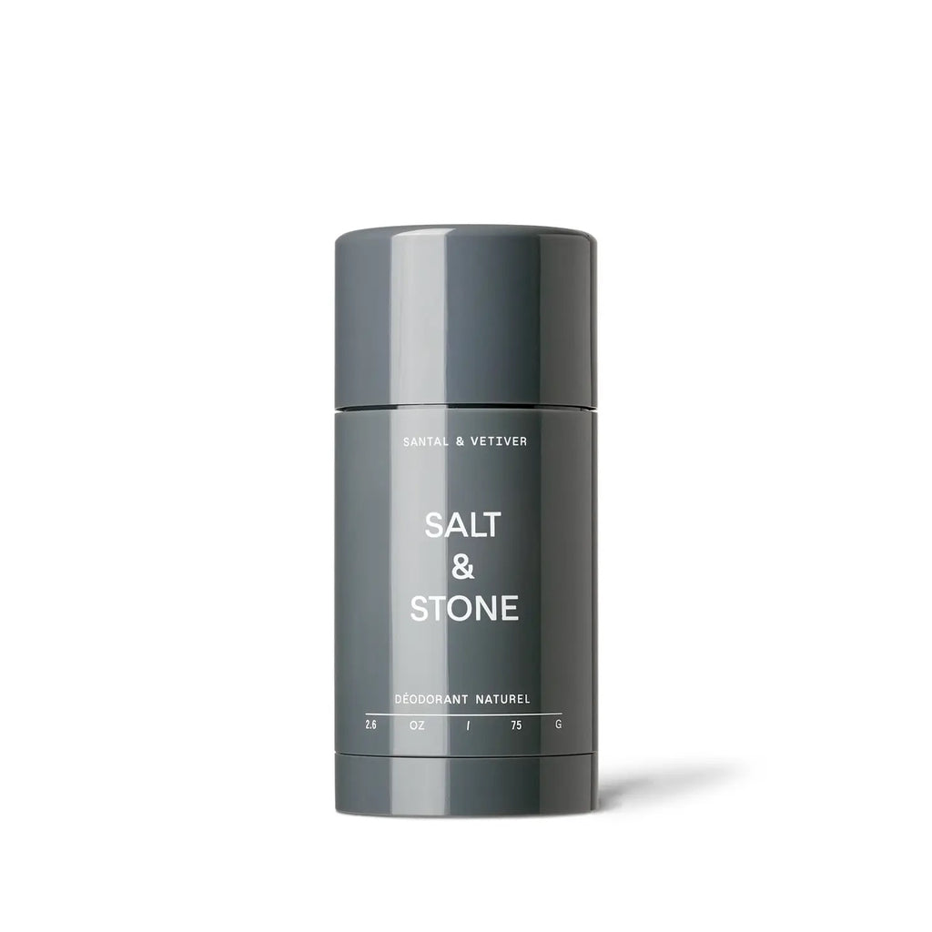 A container of salt & stone natural deodorant with santal and vetiver on a plain background.