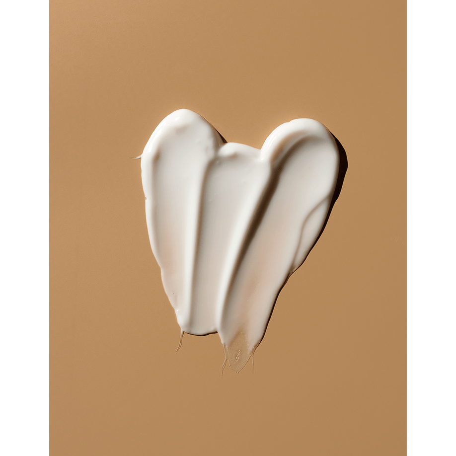 A heart shape made of white creamy substance on a tan background.