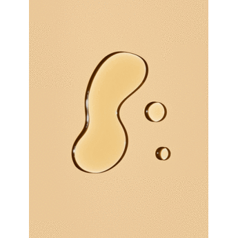 Droplets of a viscous fluid in varying sizes on a beige background.