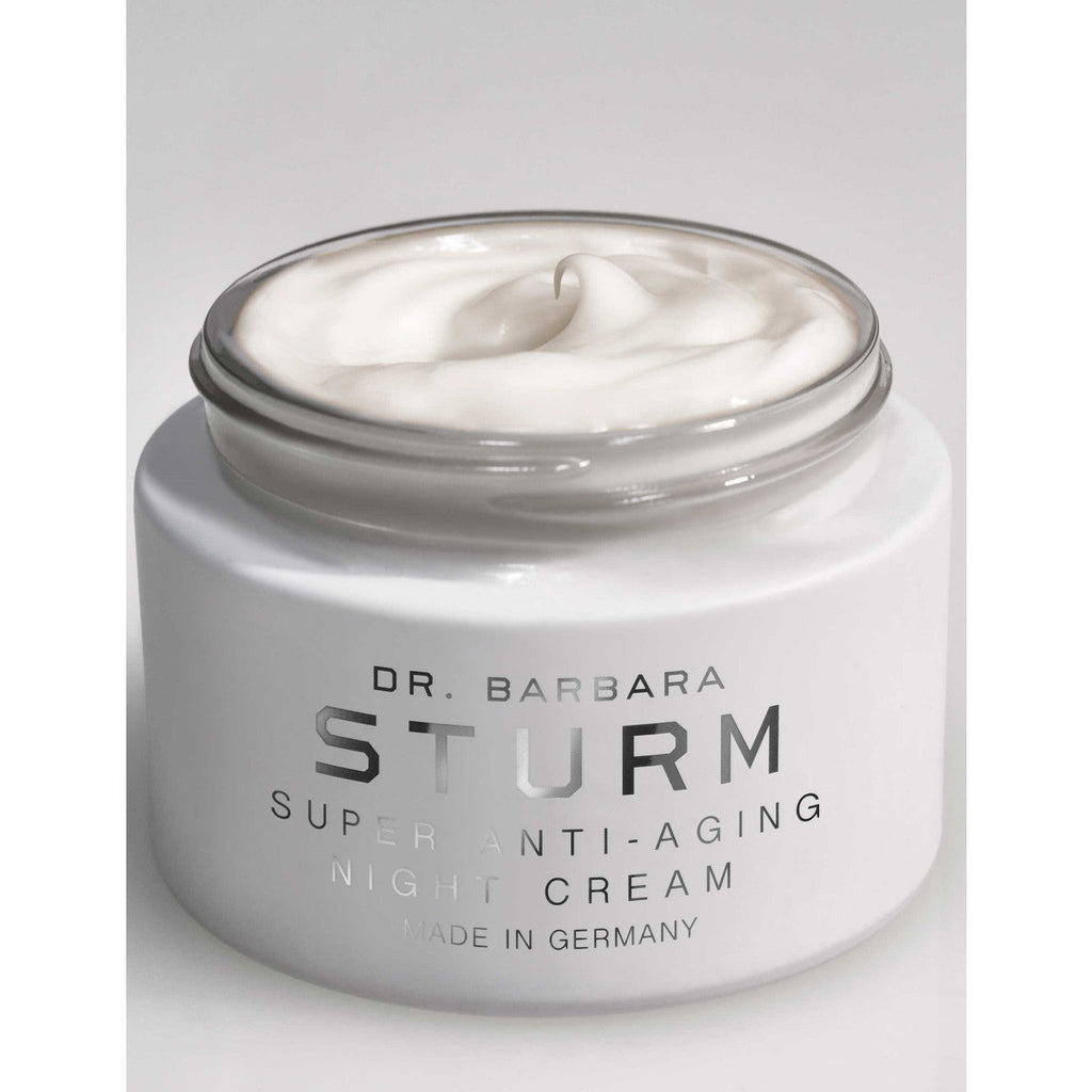 Open jar of dr. barbara sturm super anti-aging night cream against a white background.