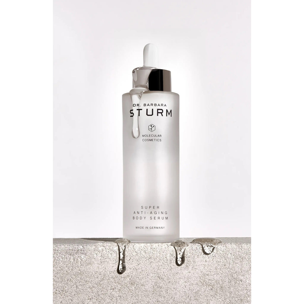 Cosmetic dropper bottle with serum dribbling down the side against a neutral background.