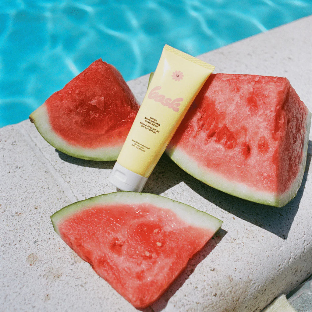 Sunscreen and watermelon slices by the poolside.