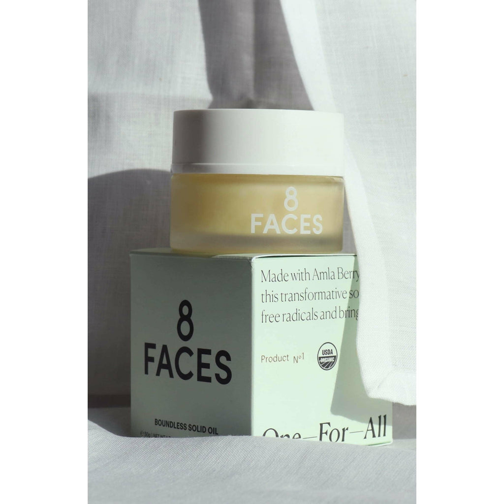 A jar of "8 faces boundless solid oil" with its packaging that highlights amla berry as a key ingredient.