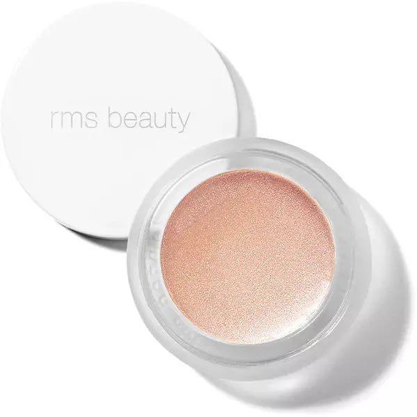 A container of rms beauty luminizer cosmetic product with its lid placed beside it.