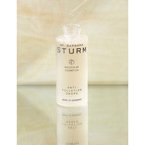 Cosmetic bottle of dr. barbara sturm face cream on a reflective surface.
