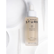 Skincare bottle from dr. barbara sturm alongside beauty products.